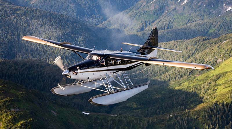 Seaplane flying over forested mountain landscape